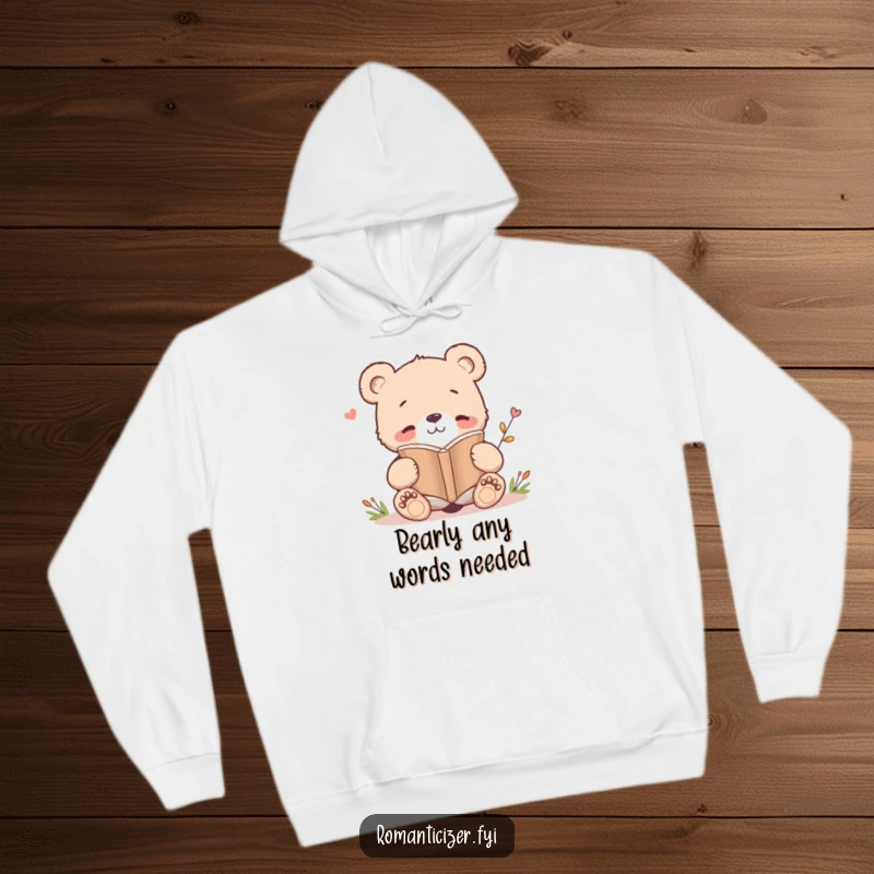 Funny hoodie depicting a smiling bear cub deeply engaged in reading a poetry book, offering warmth and literary-themed humor.