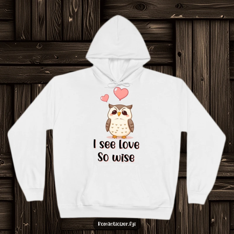 Funny hoodie with a contented owl perched, looking up at two ethereal hearts floating gently towards the top of the design.