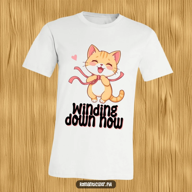 Funny cat t-shirt illustrating a playful cat joyfully twirling with a long ribbon, a contented sigh visible. Whimsical and fun apparel.